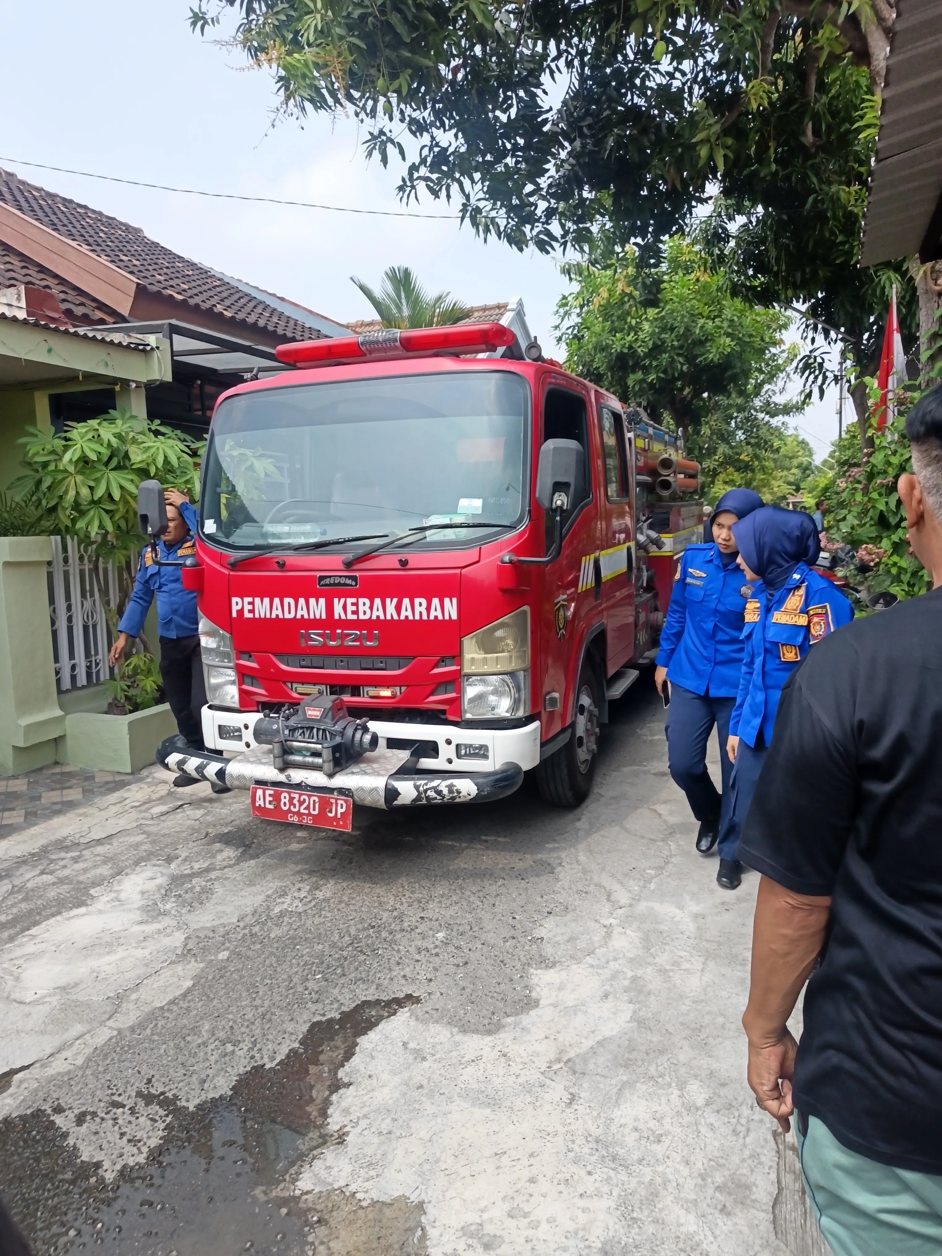 Petugas Damkar Kabupaten Ngawi memadamkan kebakaran rumah di Perumahan Loka Wiyata yang diduga dipicu kompor gas masih menyala. 